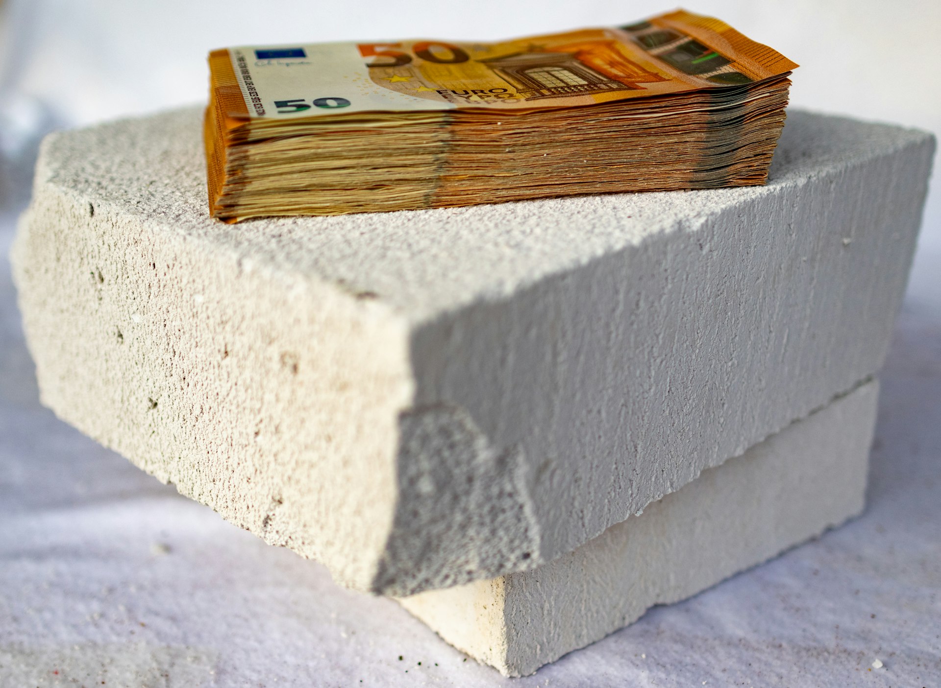 a stack of money sitting on top of a cement block